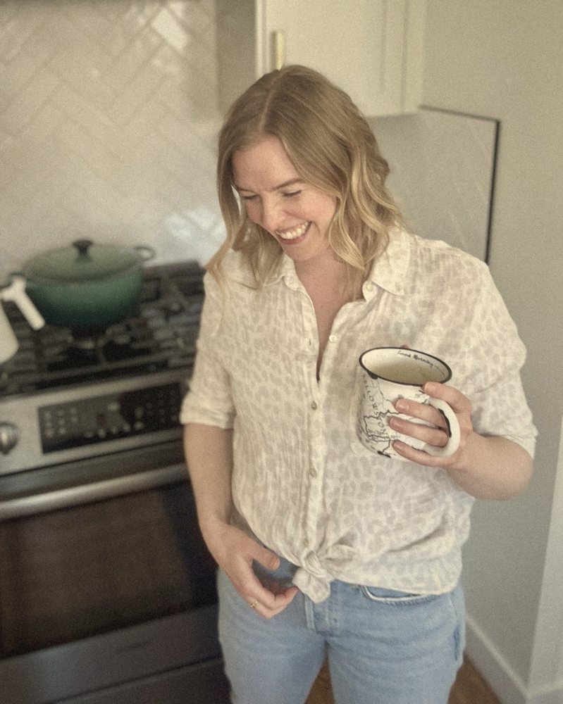 Callie laughing in her kitchen, holding a mug